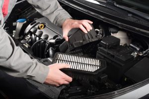 Mechanic changing the air filter on a car royalty free image